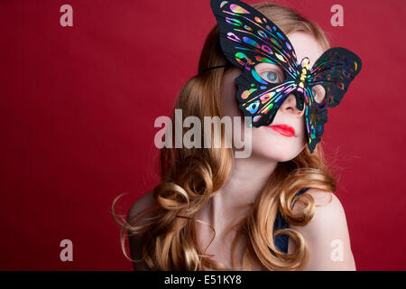 Porträt von Teenager-Mädchen mit Schmetterling-Maske Stockfoto