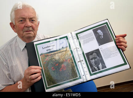 Rostock, Deutschland. 16. Juli 2014. Gerhard Fischer, Initiator der Gedenkstätte "Bauern gegen den Nationalsozialismus," hält ein Programm für den Standort in Göhren in der Nähe von Rostock, Deutschland, 16. Juli 2014. Die neue Dauerausstellung mit Porträts von 31 Frauen und Männern und die Namen der 120 anderen mutigen Menschen wurde im alten Zollhaus in Göhren feierlich eröffnet. Foto: BERND WUESTNECK/Dpa/Alamy Live News Stockfoto