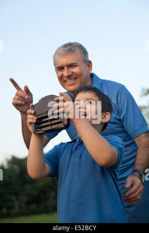 Großvater und junge spielt mit Radio gesteuert Mobilteil Stockfoto