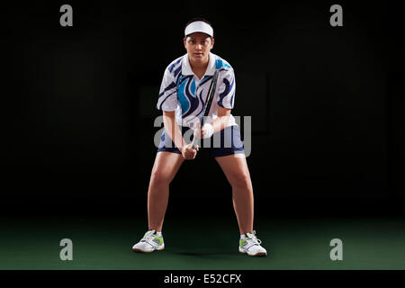 Porträt der jungen Spielerin mit Tennisschläger auf schwarzem Hintergrund Stockfoto