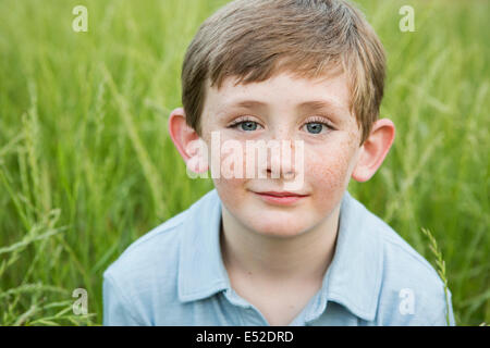 Ein Junge in ein blaues Hemd mit braunem Haar und Sommersprossen. Stockfoto