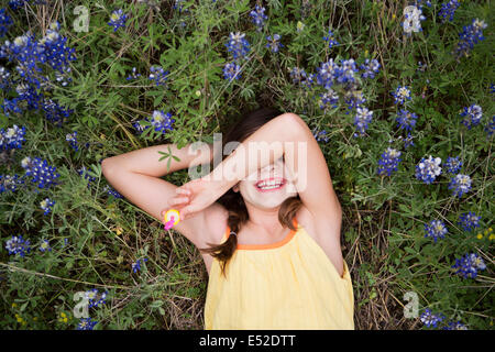 Ein junges Mädchen auf dem Rücken liegend mit dem Arm über die Augen. Stockfoto