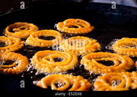 Nahaufnahme des köstlichen Jalebis Braten in Öl Pfanne am stall Stockfoto