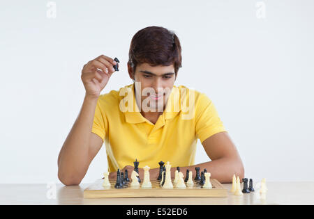 Junger Mann spielt Schach Stockfoto