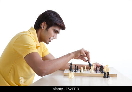 Junger Mann spielt Schach Stockfoto