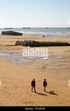 Besucher erkunden die Reste der Mulberry Hafen am Strand von Arromanches Normandie Frankreich im Juli Stockfoto