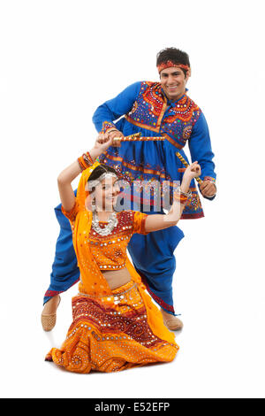 Porträt des jungen indischen Brautpaar durchführen Dandiya Raas auf weißem Hintergrund Stockfoto