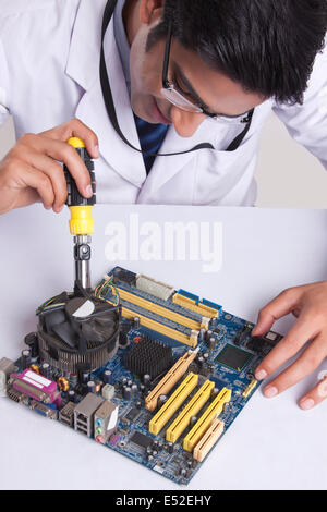 Erhöhte Ansicht der männlichen Techniker arbeiten an Hauptplatine am Tisch Stockfoto