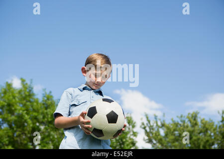 Ein kleiner Junge hält einen Fußball. Stockfoto