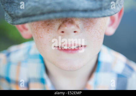 Ein kleiner Junge mit einer sommersprossige Nase trägt eine Mütze mit großer Krempe. Stockfoto