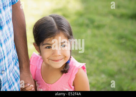 Ein kleines Kind in einem rosa Kleid ihres Vaters Hand hält. Stockfoto