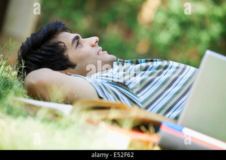 Student in einem Park liegend Stockfoto