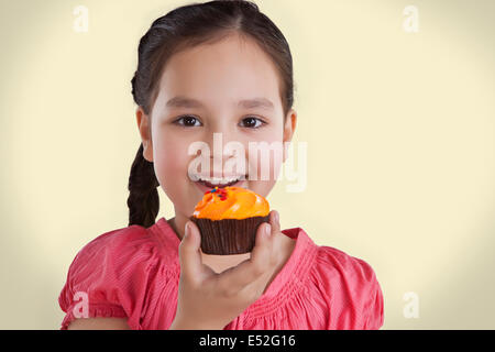 Porträt eines Mädchens einen Cupcake Essen Stockfoto