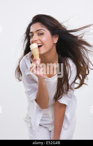 Porträt der glückliche junge Frau genießen Eis isoliert auf weißem Hintergrund Stockfoto