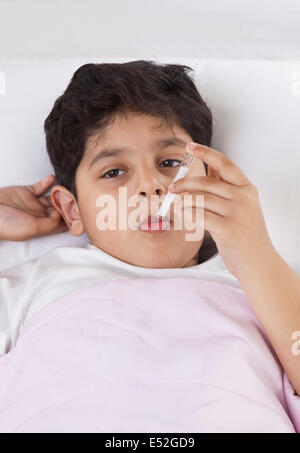 Kleiner Junge mit Thermometer in den Mund Stockfoto