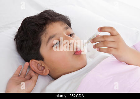 Kleiner Junge mit Thermometer in den Mund Stockfoto