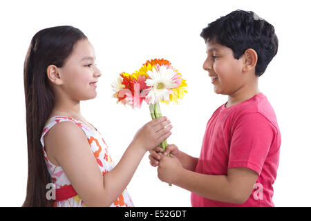 Junge zu einem Mädchen Blumen schenken Stockfoto