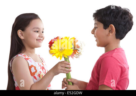 Junge zu einem Mädchen Blumen schenken Stockfoto