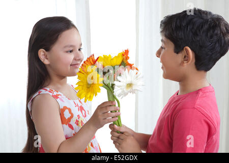 Junge zu einem Mädchen Blumen schenken Stockfoto