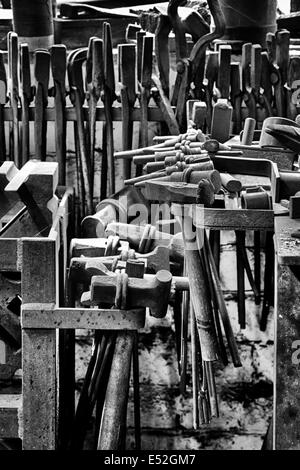 Schmiede-Werkzeuge in einer Werkstatt. Schüren Sie Bruerne, Northamptonshire, England. Monochrom Stockfoto