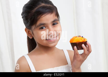 Porträt eines Mädchens halten einen cupcake Stockfoto