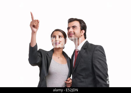 Lächelnd Geschäftsfrau zeigt etwas an Kollegen vor weißem Hintergrund Stockfoto