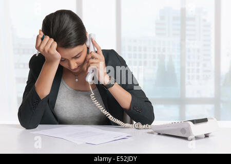 Besorgt Geschäftsfrau Beantwortung Telefon am Schreibtisch Stockfoto