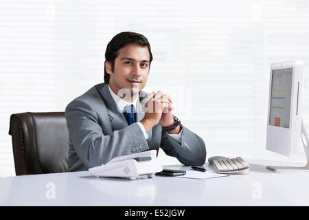Porträt von zuversichtlich Geschäftsmann sitzt am Schreibtisch Stockfoto