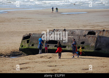 Besucher erkunden die Reste der Mulberry Hafen am Strand von Arromanches Normandie Frankreich im Juli Stockfoto