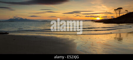 Panorama-Landschaft eines Sonnenuntergangs über Süd Skye und Rhum aus Camusdarach Strand, Arisaig, Highland, Schottland. Stockfoto