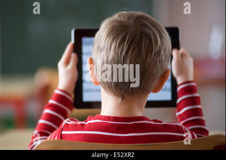 Schuljunge im Klassenzimmer mit iPad Stockfoto
