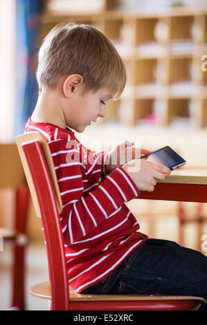 Schuljunge im Klassenzimmer mit iPad Stockfoto