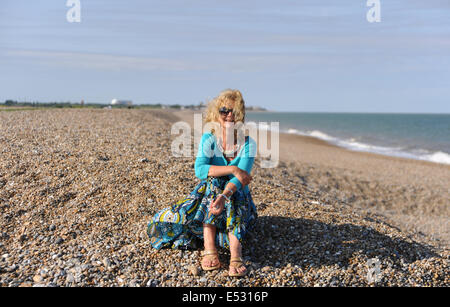 Aldeburgh Suffolk UK - Blick auf die Küstenstadt Suffolk Von Aldeburgh - Frau sitzt am Strand im Urlaub Stockfoto