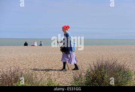 Aldeburgh Suffolk UK - Blick auf die Küstenstadt Aldeburgh Lady, die mit einem Stock am Strand entlang geht Stockfoto