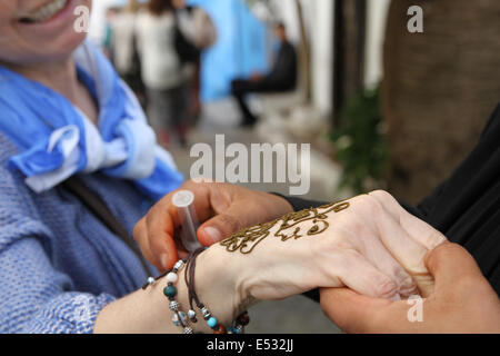 Eine Frau bekommt eine Henna-Tattoo auf ihrer Hand in Marokko Stockfoto