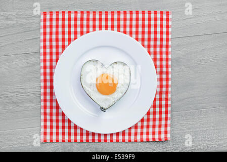 Spiegelei in Herzform auf Vintage Tisch. Frühstück für einen lieben Menschen Stockfoto