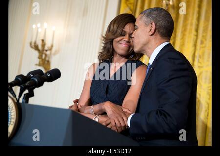US-Präsident Barack Obama küsst First Lady Michelle Obama nach ihre Bemerkungen an eine bezahlbare Pflege Act-Rezeption im East Room des weißen Hauses 1. Mai 2014 in Washington, DC. Stockfoto