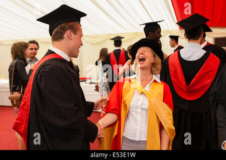 Ein Studium Student (Daniel Rooney) von der University of West England teilt einen Witz mit seinem Lehrer bei seinem Abschluss-Zeremonie Stockfoto