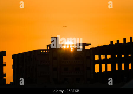 Flugzeug abheben bei Sonnenuntergang über Ruinen Stockfoto