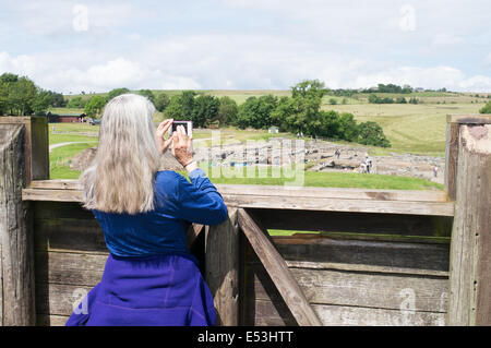 Weibliche Besucher Vindolanda römisches Kastell mit dem Fotografieren der Ausgrabungen Northumberland England UK Stockfoto