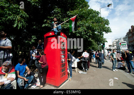 London UK. 19. Juli 2014.  Ein Demonstrant befindet sich auf einer Telefonzelle mit einem Palästina-Flagge während einer Protestaktion vor der israelischen Botschaft in London, um Unterstützung für das palästinensische Volk und gegen laufende israelische Militärschläge in Gaza Kredit zeigen: Amer Ghazzal/Alamy Live-Nachrichten Stockfoto