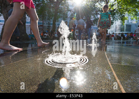 Leicester Square, London, UK. 19. Juli 2014. Londoner und Touristen genießen die Brunnen am Leicester Square rund um die Statue von William Shakespeare. Bildnachweis: Matthew Chattle/Alamy Live-Nachrichten Stockfoto