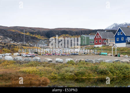 Friedhof in Qeqertarsuaq, Grönland mit Gräbern und Häuser Stockfoto