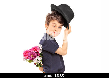 Profil-Schuss eines niedlichen kleinen Jungen halten Blumen hinter seinem Rücken Stockfoto