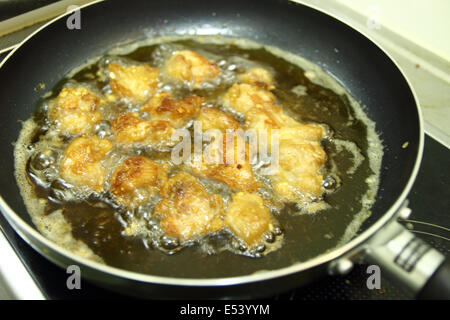 Hähnchen-Nuggets im heißen Öl in einer Pfanne Stockfoto