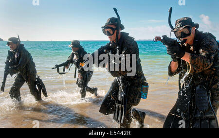 US-Marines Sonderbetrieb zwingt mit japanischen Boden Selbstverteidigung Soldaten aus dem Wasser, beim üben kleine Maßeinheit Niveau Techniken im Rahmen des Austauschprogramms für Japan Beobachter am Kin Blue Beach 16. Juli 2014 in Okinawa, Japan auftauchen. Stockfoto