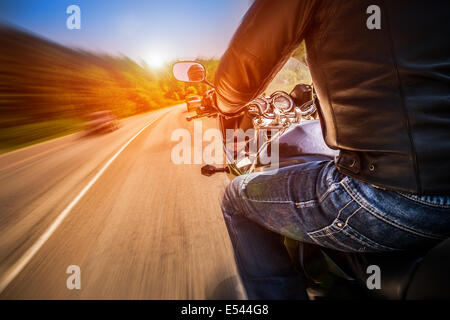 Biker fahren ein Motorrad fährt entlang der asphaltierten Straße. Stockfoto