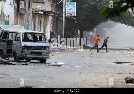 Gaza, Palästinensische Gebiete. 20. Juli 2014. Palästinenser laufen in der Straße am Al Shejaiyaa Nachbarschaft im Osten von Gaza-Stadt an der Grenze zwischen Israel und Gaza-Stadt, 20. Juli 2014. Zig Tausende von Palästinensern in der Bereich, der in unmittelbarer Nähe verließen ihre Häuser in den letzten Tagen, Schutz von einem israelischen Bodeninvasion zu suchen. Israel drängte seine Bodenoffensive in südlichen Gazastreifen Credit: ZUMA Press, Inc./Alamy Live News Stockfoto