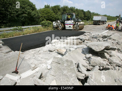 Goch, Deutschland. 20. Juli 2014. Arbeiter reparieren Autobahn 57 in Richtung Köln in Goch, Deutschland, 20. Juli 2014. Ein 3,5 Kilometer langes Teilstück der Autobahn wurde geschlossen, nachdem die Hitze verursacht in der Fahrbahn in der Nähe von Goch an der niederländischen Grenze Risse. Foto: ROLAND WEIHRAUCH/Dpa/Alamy Live News Stockfoto