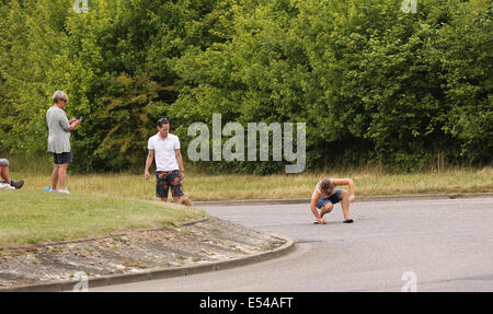 Junge Frau auf der Straße bereit für die Tour de France, die in Yorkshire, am 3. Tag in der Nähe von Cambridge begonnen zu schreiben. 7. Juli 2014 Stockfoto